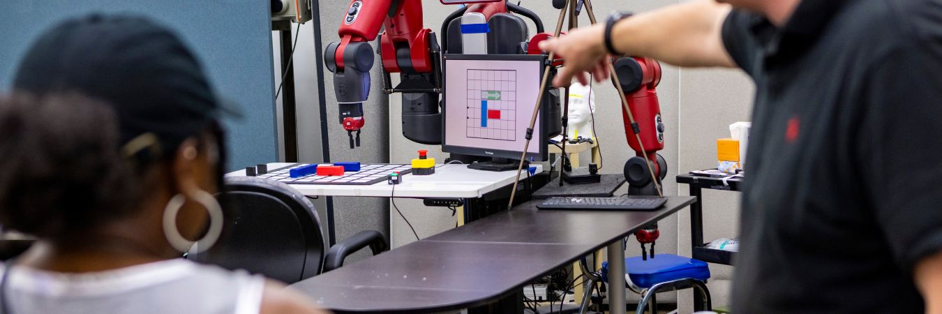 Students working at table with lans and computer parts